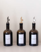 Three amber glass bottles with labels on a white background